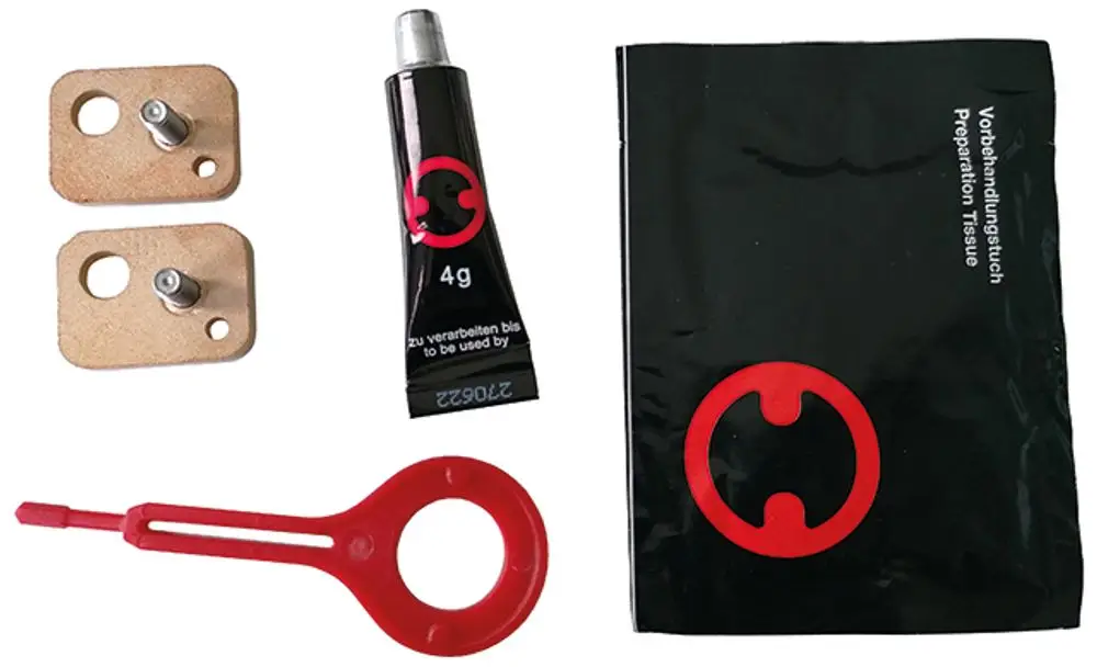 SYR Klebeset mit zwei Platten, einem Tuben Kleber und einer roten Halterung. Alles in einem schwarzen Säckchen mit rotem Logo.